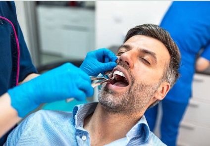 Dentist performing a tooth extraction under local anaesthesia