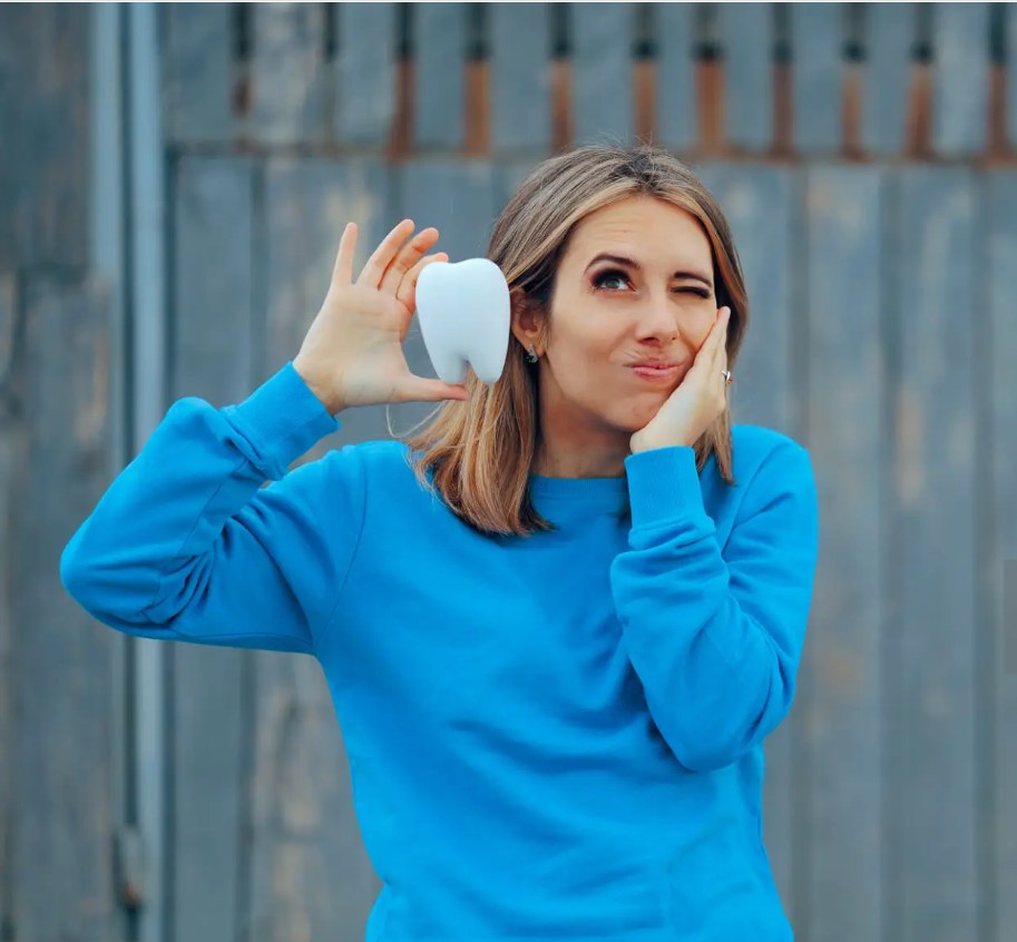 Woman holding a model tooth — wisdom teeth removal at Dr Pierre Dentistry Edgecliff